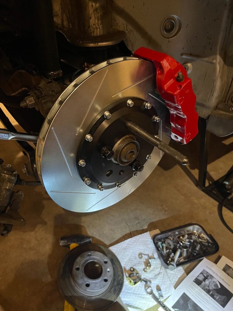 Red brake caliper and slotted rotor.